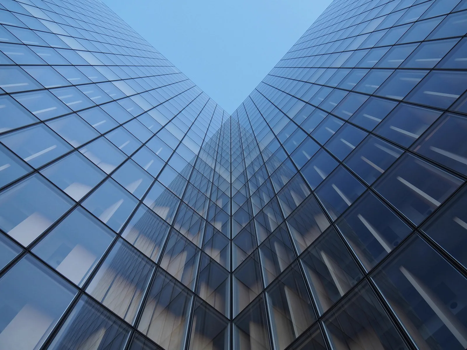 Dos torres de oficinas acristaladas convergiendo hacia el cielo